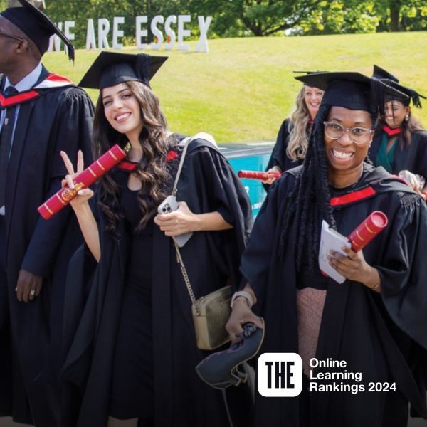Two people in black and red graduation outfits celebrating